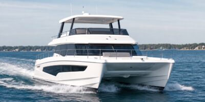 Unbranded modern power catamaran underway with twin hulls and flybridge